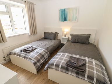 A bedroom with two single beds side by side with gray bedding and plaid blankets at Butterfly Lodge in Tunstall near Catterick North Yorkshire