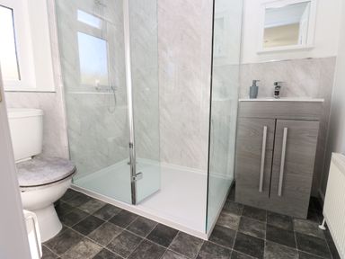 A bathroom with a toilet a glass shower enclosure and a sink with a cabinet at Butterfly Lodge in Tunstall near Catterick North Yorkshire
