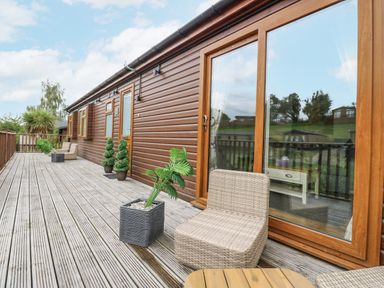 An outdoor area with decking and seating at Butterfly Lodge in Tunstall near Catterick, North Yorkshire