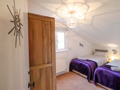 A bedroom with two beds and a wardrobe at Bryn Y Garreg - The Wireless Free Farm (No Tech!) Y Trallwng