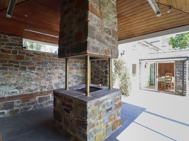 An outdoor kitchen with a stone cooking area and a support column at Bryn Y Garreg Cottage - The Wireless Free Farm, Llangadfan near Llanwddyn