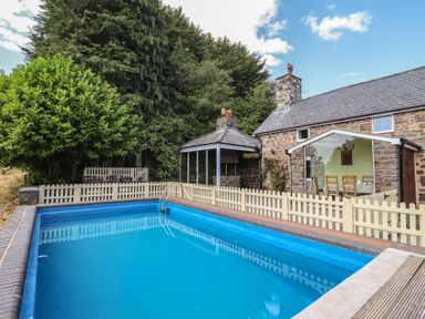 An outdoor area with a swimming pool and fenced yard at Bryn Y Garreg Cottage - The Wireless Free Farm, Llangadfan near Llanwddyn