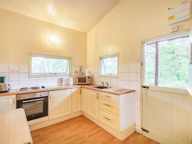 A kitchen with oven microwave sink and wooden countertops at The Log Cabin in Sheldon Blackdown Hills