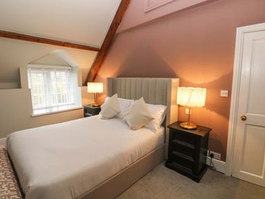 A bedroom with a double bed two bedside tables with lamps and a window with blinds at Norchard Farm House Redberth near St Florence