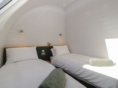A bedroom with two single beds and white walls at Leadon View Willow in Upleadon near Newent