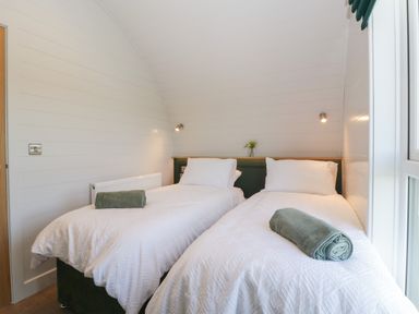 A bedroom with two single beds towels on beds and a window at Leadon View Willow in Upleadon near Newent
