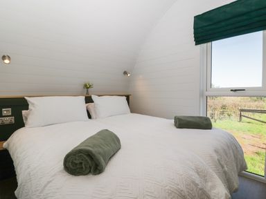 A bedroom with two beds with white bedding and green towels by a window at Leadon View Willow in Upleadon near Newent