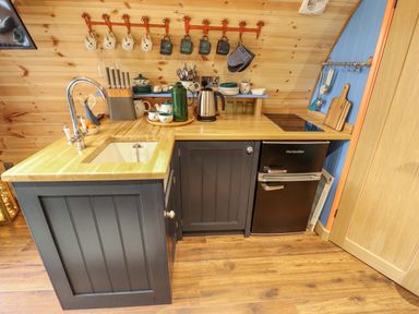A kitchen corner with a sink a faucet a knife block and a small refrigerator at Hobhole in Keal Cotes near East Kirkby
