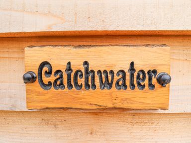 A wooden sign with the word Catchwater attached to a wooden surface