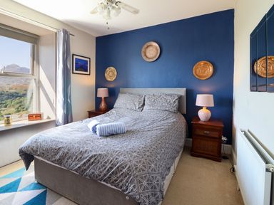 A bedroom with a double bed two bedside tables with lamps and a window with a view at Hendre in Blaenau Ffestiniog