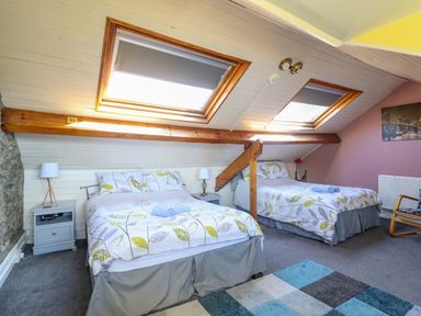 A bedroom with two beds under skylights and nightstands at Hendre in Blaenau Ffestiniog