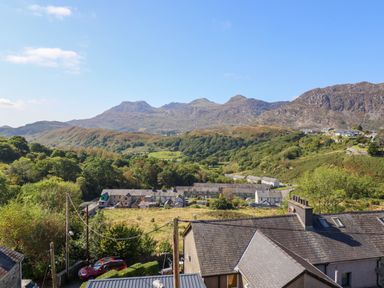 A landscape view of houses with hills and mountains in the background at Hendre in Blaenau Ffestiniog