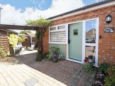 An entrance area with a door and potted plants at Rainbow's End in Swanton Morley