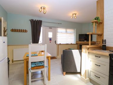 A kitchen with a dining table and a refrigerator at Rainbow's End in Swanton Morley