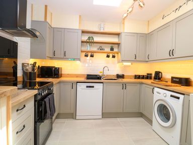 A kitchen with cabinets, appliances and utensils at Rainbow's End in Swanton Morley
