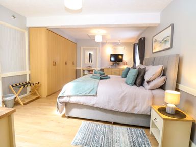 A bedroom with a bed and wardrobe at Rainbow's End in Swanton Morley