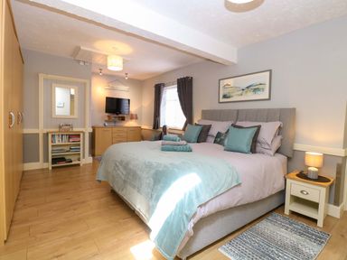 A bedroom with a double bed and television at Rainbow's End in Swanton Morley