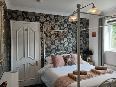 A bedroom with a bed and wall art at The Corner House in Ufford near Woodbridge