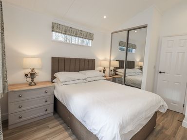A bedroom with a bed and nightstand at Lakeside Lodge Bowland Lakes Leisure Village near Garstang