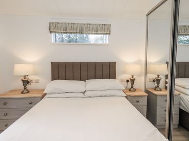 A bedroom with a bed and nightstands at Lakeside Lodge Bowland Lakes Leisure Village near Garstang