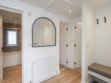 A hallway with a mirror and a bench at Lakeside Lodge Bowland Lakes Leisure Village near Garstang