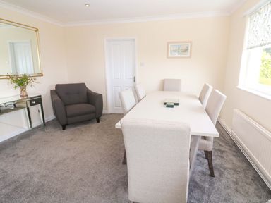 A dining room with a table and chairs at Karenza in Penzance