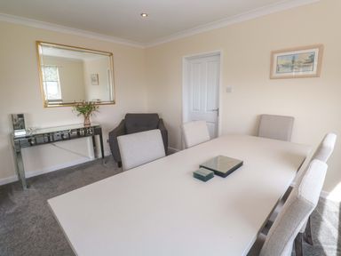 A dining room with a table and chairs at Karenza in Penzance