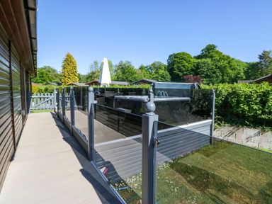 An outdoor balcony with a hot tub at Dovedale Lodge in Troutbeck Bridge
