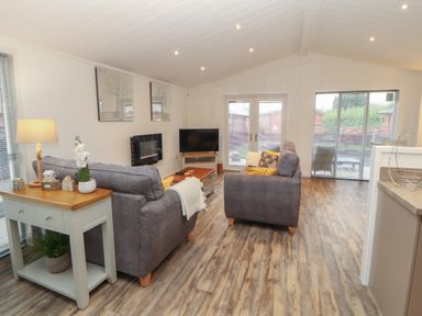 A living room with sofas and a television at Dovedale Lodge in Bowness 70, White Cross Bay near Windermere