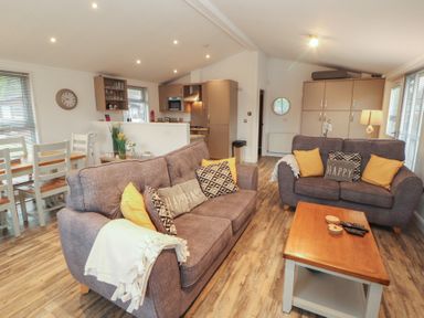 A living room with sofas and dining area at Dovedale Lodge Bowness 70, White Cross Bay near Windermere