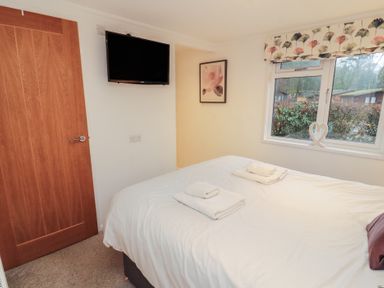 A bedroom with a bed and a television at Dovedale Lodge Bowness 70, White Cross Bay near Windermere