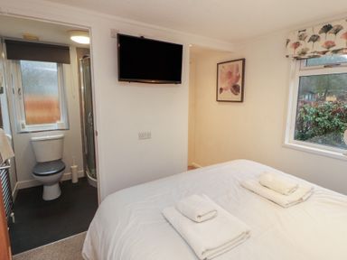 A bedroom with a bed and television at Dovedale Lodge in Bowness 70, White Cross Bay near Windermere