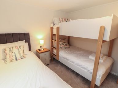 A bedroom with a double bed and a bunk bed at Dovedale Lodge Bowness 70 White Cross Bay near Windermere