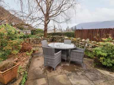 A garden with a table and chairs at Jasmine Cottage Thornthwaite