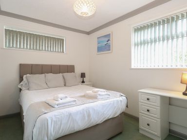 A bedroom with a double bed and folded towels on it at White Gables in Horning