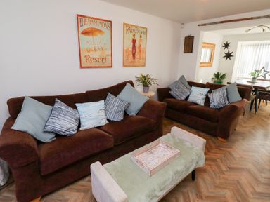 A living room with two brown sofas and a coffee table with a tray at Coastal Retreat in Seahouses