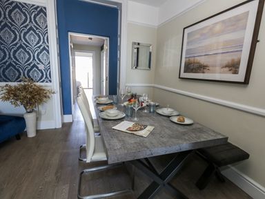 A dining room with a table set for a meal at Apartment 1 in Weymouth