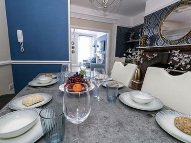 A dining table set with plates and fruit at Apartment 1 in Weymouth