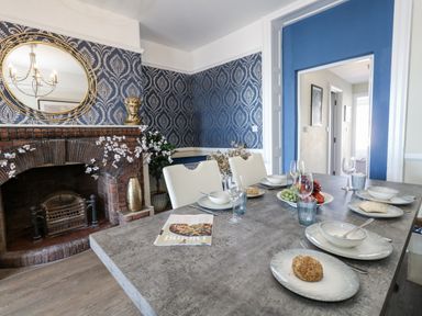A dining room with a table set for a meal at Apartment 1 Weymouth
