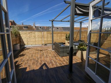 A terrace with outdoor seating and potted plants at Apartment 1 in Weymouth