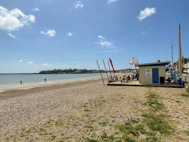 A beach with a café and people walking at Apartment 1 Weymouth