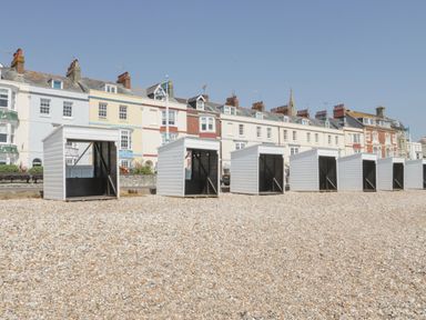 A row of beach huts on a pebbly beach at Apartment 1 Weymouth
