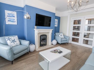 A living room with a television and sofa at Vista Mare 1 in Weymouth