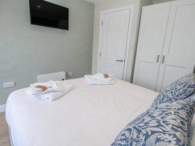A bedroom with a bed and television at Vista Mare 1 Weymouth
