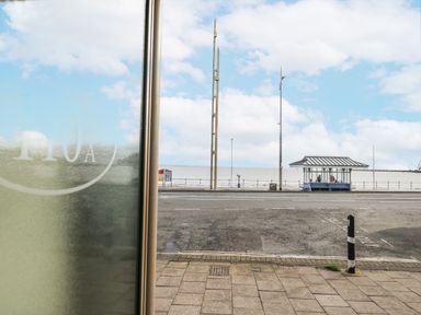 View of the sea and road with light poles and a bus shelter at Vista Mare 1 in Weymouth