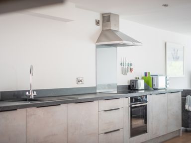 A kitchen with a sink stove oven toaster cutting boards microwave and knives at Hoheck in Abersoch