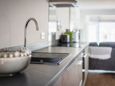 A kitchen countertop with a sink and faucet and a bowl on the counter at Hoheck in Abersoch
