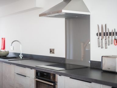 A kitchen countertop with a sink stove oven toaster and knives on a magnetic strip at Hoheck in Abersoch