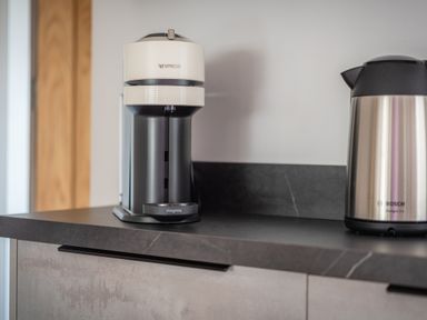 A coffee machine and an electric kettle on a kitchen countertop at Hoheck in Abersoch