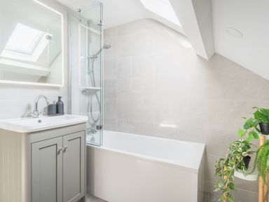 A bathroom with a bathtub shower sink cabinet and plants at Hoheck in Abersoch